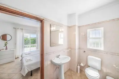 a white bathroom with a sink and a toilet at Villa Alecrim in Albufeira