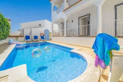 a swimming pool in the backyard of a house at Villa Alecrim in Albufeira