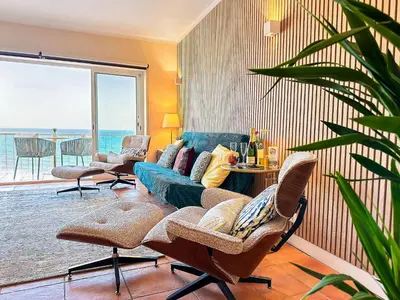 a living room with a couch and a table with chairs at OceanView Apartment by BeCherish in Albufeira