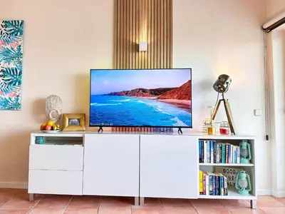 a living room with a tv on a white cabinet at OceanView Apartment by BeCherish in Albufeira