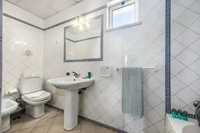a white bathroom with a sink and a toilet at Villa Oahu in Albufeira