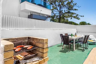 a patio with a table and chairs and a grill at Villa Rum Cay in Albufeira