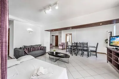 two beds in a room with purple sheets and a window at Villa Rum Cay in Albufeira