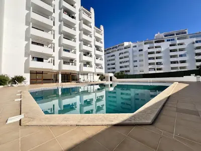 a swimming pool in front of two buildings at Albufeira Town Apartment With Pool by Homing in Albufeira