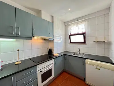 a kitchen with blue cabinets and a sink at Albufeira Central 9 by Homing in Albufeira