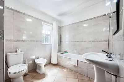 a white bathroom with a toilet and a sink at Villa Jasmin Marina in Albufeira