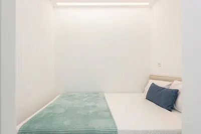 a white bedroom with a bed with blue pillows at BLUE - Vilamoura in Vilamoura