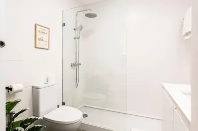 a white bathroom with a toilet and a shower at BLUE - Vilamoura in Vilamoura