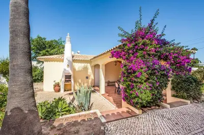 a church with flowers in front of a house at Villa Pardal in Albufeira