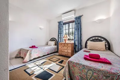 a bedroom with two beds and a window at Villa Pardal in Albufeira