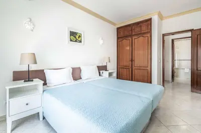 a bedroom with a blue bed and a wooden cabinet at Villa Palawan in Galé