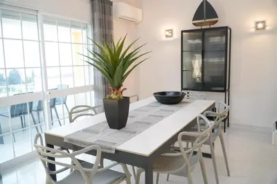 a dining room table with chairs and a plant on it at Apartment Berardo - Perfect for families in Albufeira