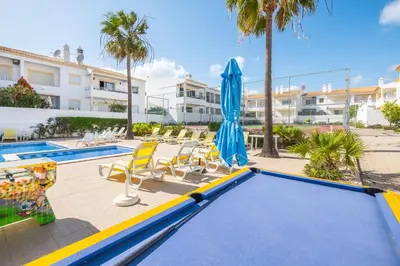 a swimming pool with a trampoline and umbrellas at Apartment Berardo - Perfect for families in Albufeira