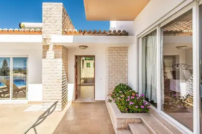 a home with a patio with a window and flowers at Villa Casa Sol in Albufeira