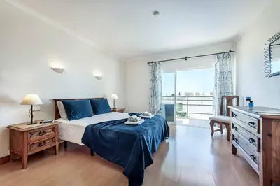a bedroom with a bed and a dresser and a window at Villa Casa Sol in Albufeira
