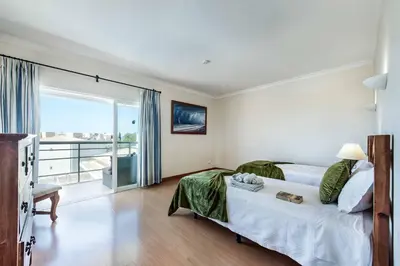 a bedroom with a large bed and a balcony at Villa Casa Sol in Albufeira