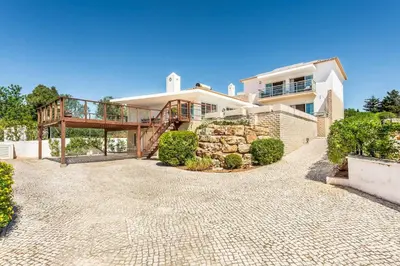 a large white house with a staircase in front of it at Villa Casa Sol in Albufeira