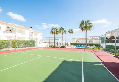 a tennis court with palm trees in the background at Apartment Nidio - Great Location in Albufeira