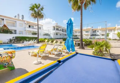 a swimming pool with a trampoline and chairs and an umbrella at Apartment Nidio - Great Location in Albufeira