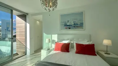 a bedroom with a bed with red pillows and a chandelier at Lua by Check-in Portugal in Albufeira