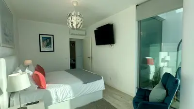 a bedroom with a bed and a chair and a window at Lua by Check-in Portugal in Albufeira