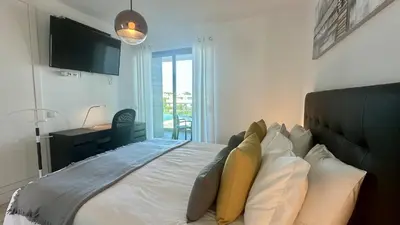 a bedroom with a bed with pillows and a television at Lua by Check-in Portugal in Albufeira