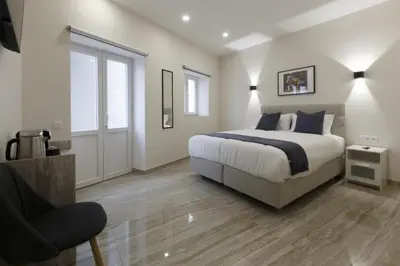 a bedroom with a bed and a chair at Solar Mendonca in Faro
