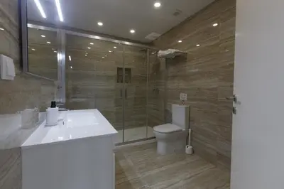 a bathroom with a toilet and a sink and a shower at Solar Mendonca in Faro