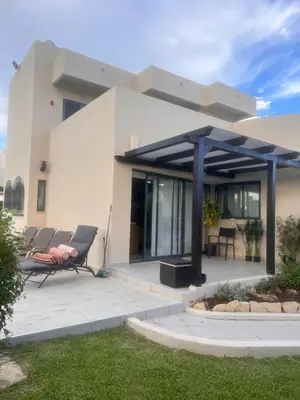 a house with a patio with two chairs at Vivenda Fairways in Quarteira