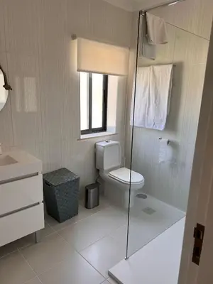 a bathroom with a toilet and a glass shower at Vivenda Fairways in Quarteira