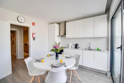 a white kitchen with a white table and chairs at Ocean Apt 200meters Beach AC Wi-Fi Balcony in Albufeira