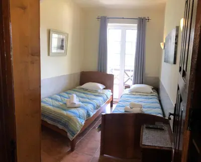 a bedroom with two beds and a window at Old Village Vilamoura Beautiful 3 Bed townhouse in Vilamoura