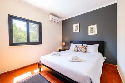 a bedroom with a large bed and a window at Villa Laranja in Guia