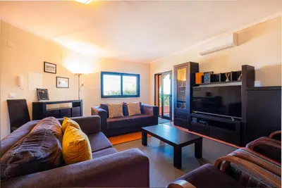 a living room with a couch and a tv at Villa Laranja in Guia