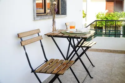 a wooden table and a chair on a patio at Apartment Marisela in Albufeira