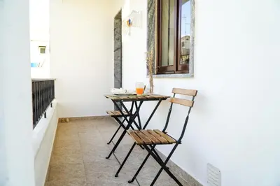 a small table on a porch with a chair at Apartment Marisela in Albufeira