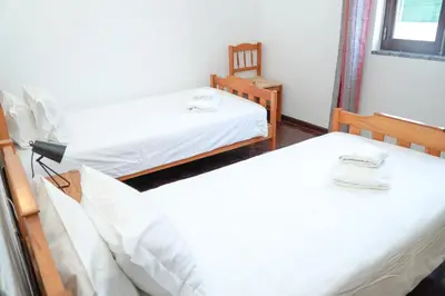 two beds in a room with white sheets at Apartment Marisela in Albufeira