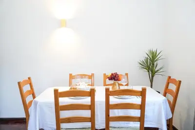 a dining room table with a white table cloth and chairs at Apartment Marisela in Albufeira