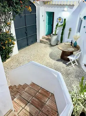 a patio with a table and a door at Casa Da Alegria in Albufeira