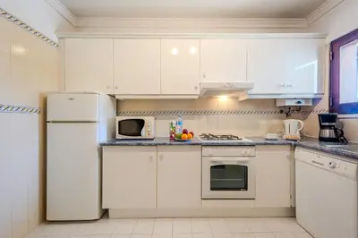 a kitchen with white cabinets and a white refrigerator at Casa Rita by Sunnyway in Olhos de Água