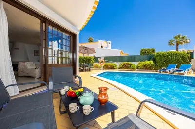 a villa with a swimming pool and a table with fruit on it at Villa Cristina 15 in Albufeira