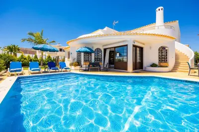 a villa with a swimming pool in front of a house at Villa Cristina 15 in Albufeira