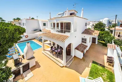 a bedroom with a bed and a sink and a mirror at Villa Serenity in Albufeira