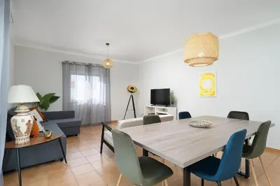 a living room with a dining room table and chairs at ISA - Quarteira in Quarteira