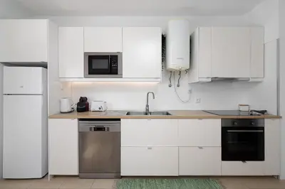a white kitchen with a sink and a microwave at ISA - Quarteira in Quarteira