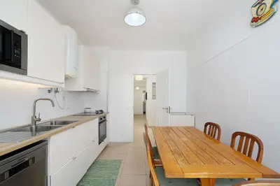 a kitchen with a wooden table and a dining room at ISA - Quarteira in Quarteira