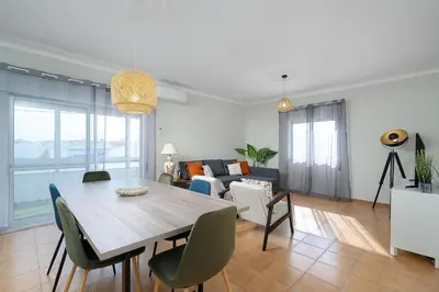 a living room with a wooden table and chairs at ISA - Quarteira in Quarteira