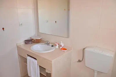 a bathroom with a sink and a toilet and a mirror at Dinita Apartamentos in Albufeira