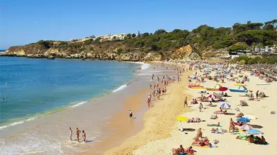 a crowd of people on a beach with the ocean at Dinita Apartamentos in Albufeira