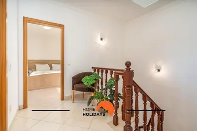 a hallway with a staircase and a chair and a mirror at #257 Villa Sun & Sea by Home Holidays in Albufeira